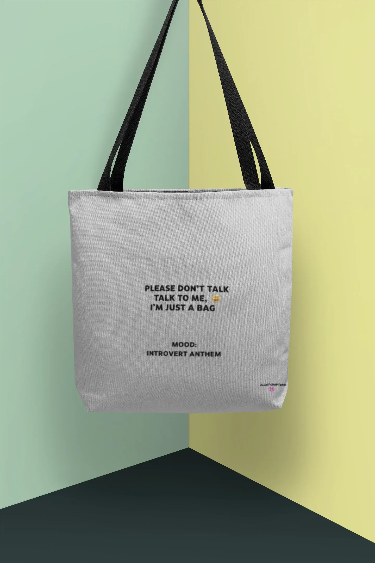 White canvas tote bag with black handles and front slogan print