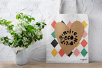 Heart-print tote bag with tan heart graphic and multicolor diamond pattern, white canvas, handles shown