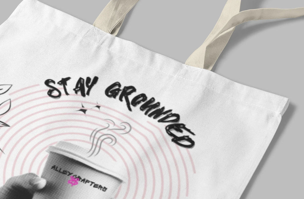 White canvas tote bag with Stay Grounded text and coffee cup graphic, floral border