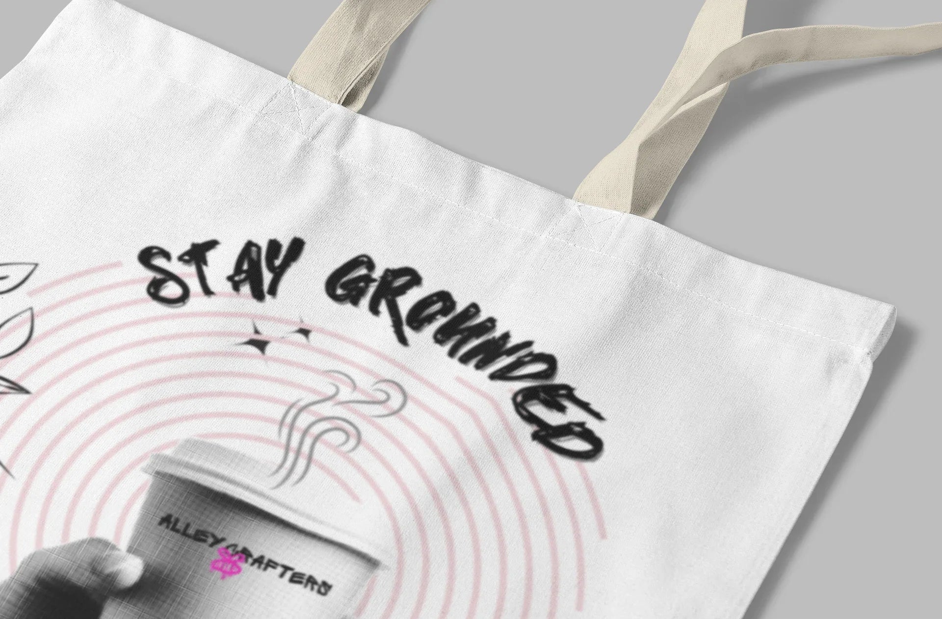 White canvas tote bag with Stay Grounded text and coffee cup graphic, floral border
