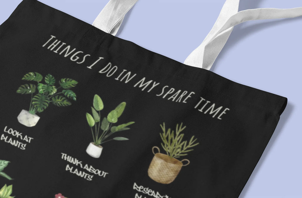 Black tote bag close-up: 'THINGS I DO IN MY SPARE TIME' over plant pots illustration.