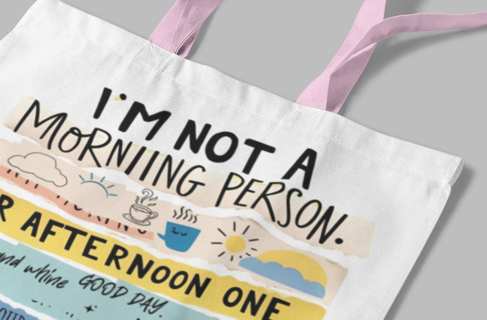 White canvas tote bag with colorful text print and pink handles