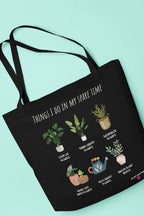Black tote bag with plant-themed graphic and phrase, wide handles