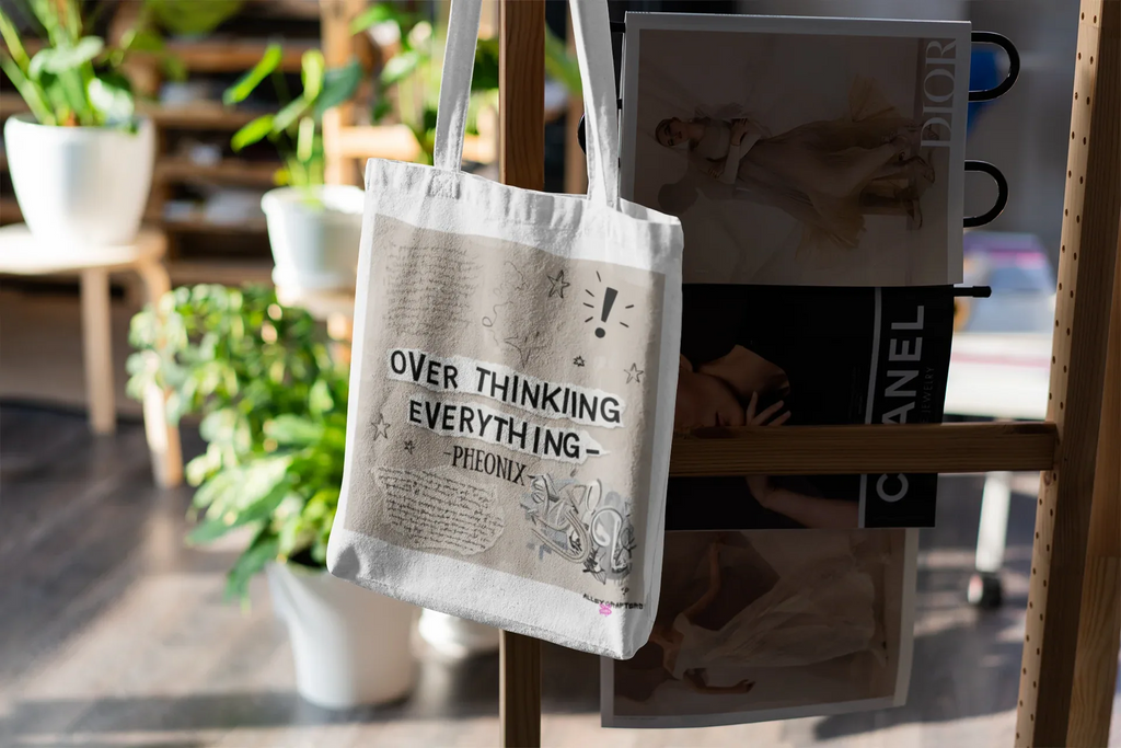 White tote bag hanging on stand, front print 'OVER THINKING EVERYTHING - Pheonix'