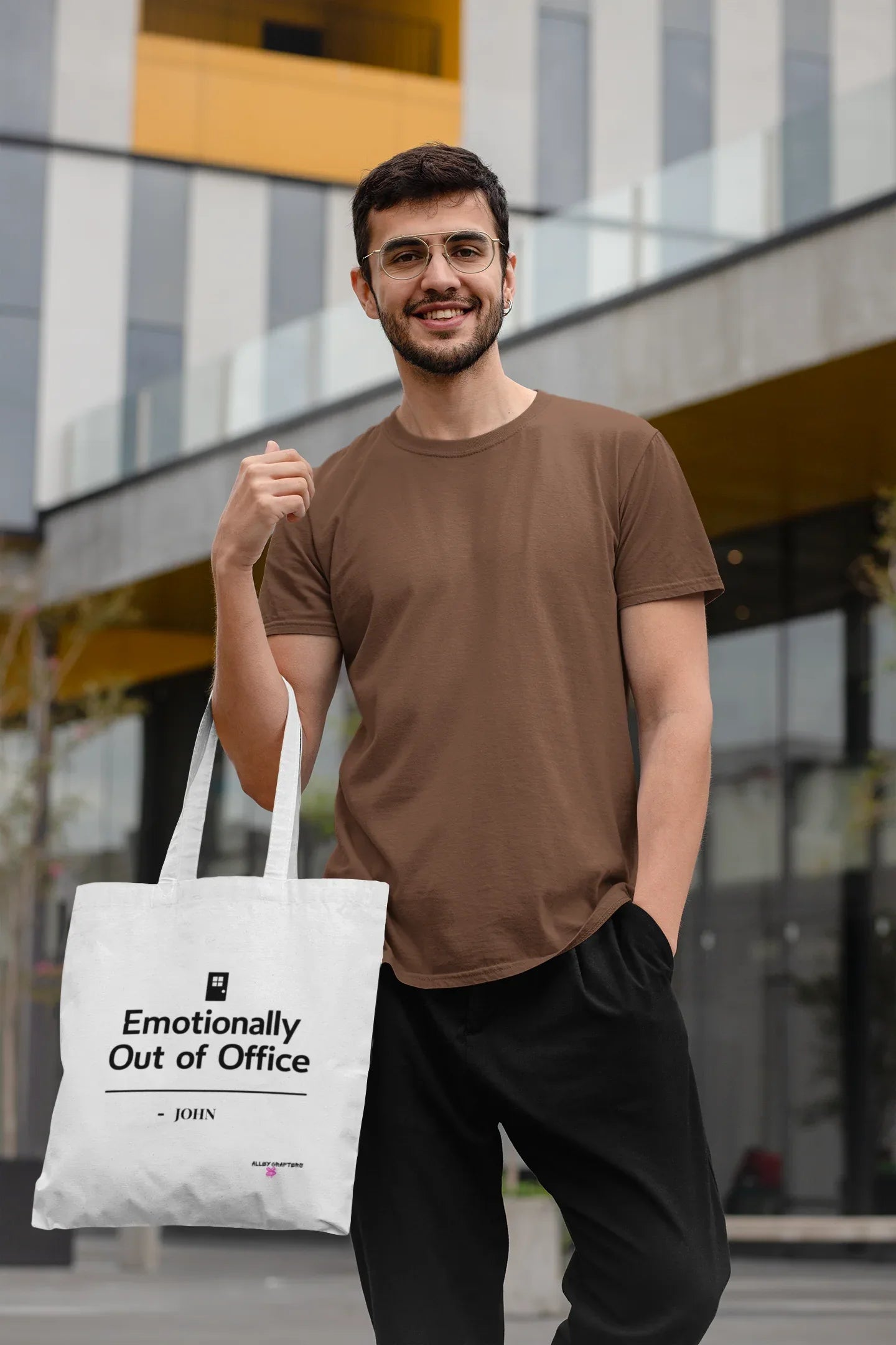 White canvas tote bag with top handles and black printed front slogan, held at side