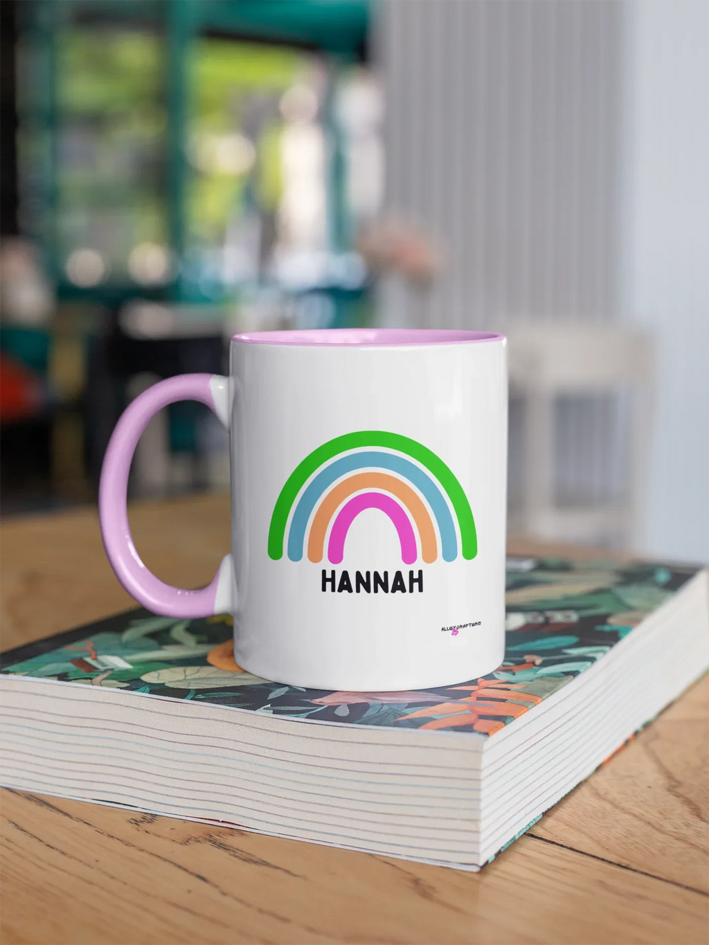 Personalised rainbow mug with HANNAH name, white body and purple handle, rainbow graphic