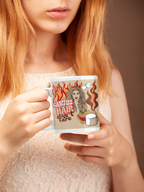 Person holding white ceramic mug with flame-haired woman and coffee cup graphic