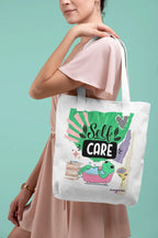 White tote bag with “Self Care” lettering and green frog artwork