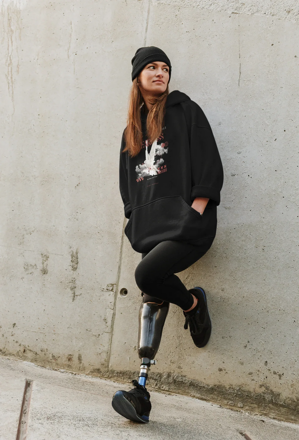 Black unisex hoodie with hood and front graphic, draped on model
