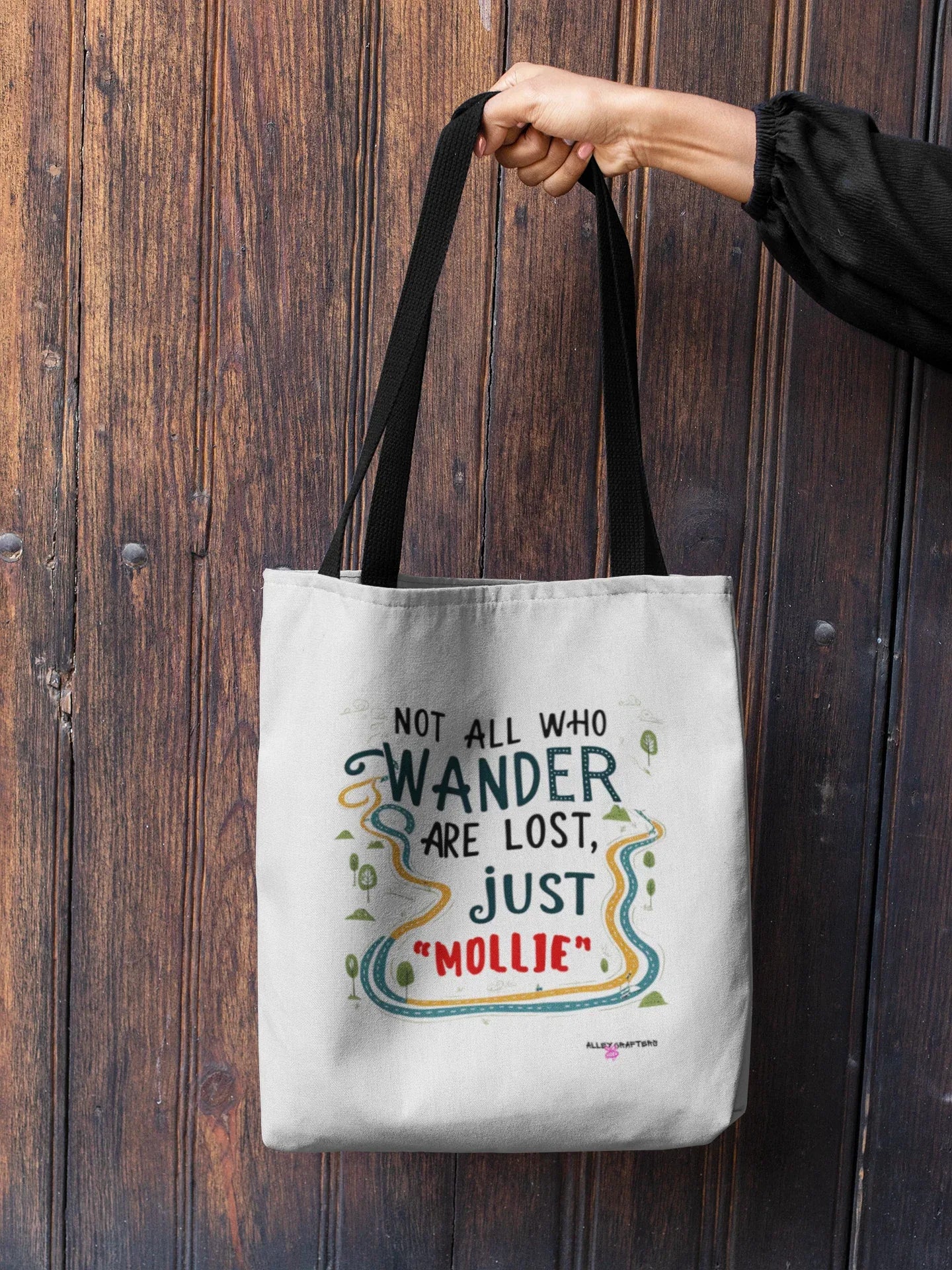 White canvas tote bag with long black handles, front quote logo with colorful lines