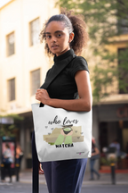 White tote bag on model, featuring “who loves MATCHA” illustration centered on front.