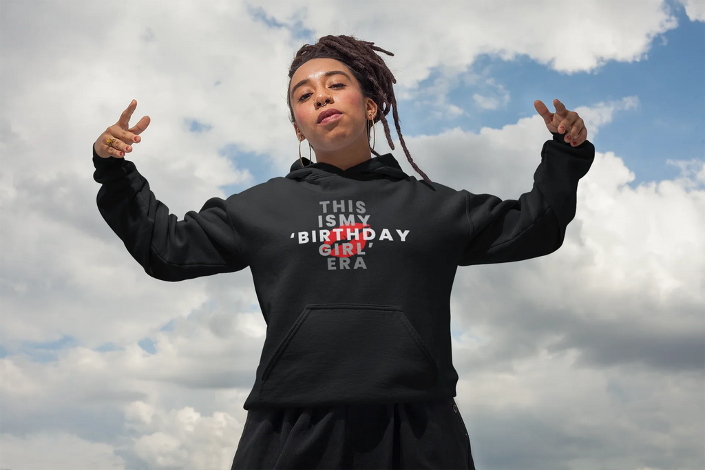 Black pullover hoodie on model with hood, wearing "THIS IS MY BIRTHDAY GIRL ERA" front print