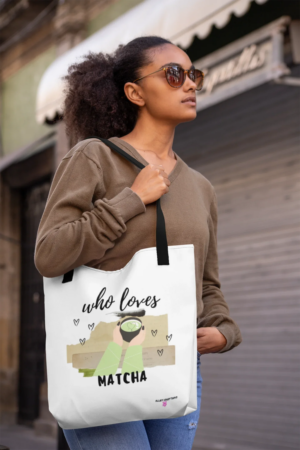 White tote bag on model, with “who loves MATCHA” print and small heart icons.
