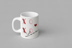 White ceramic mug with red XO hearts and cursive “Love” near the base