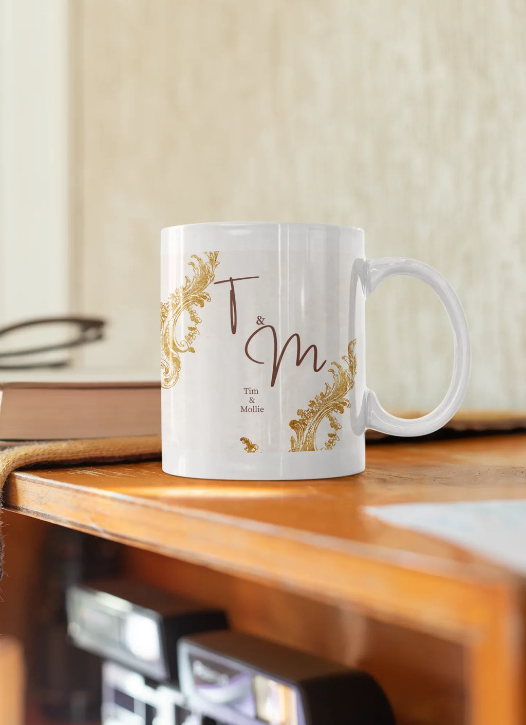 White mug with gold filigree corners and dark red 'T & M' design