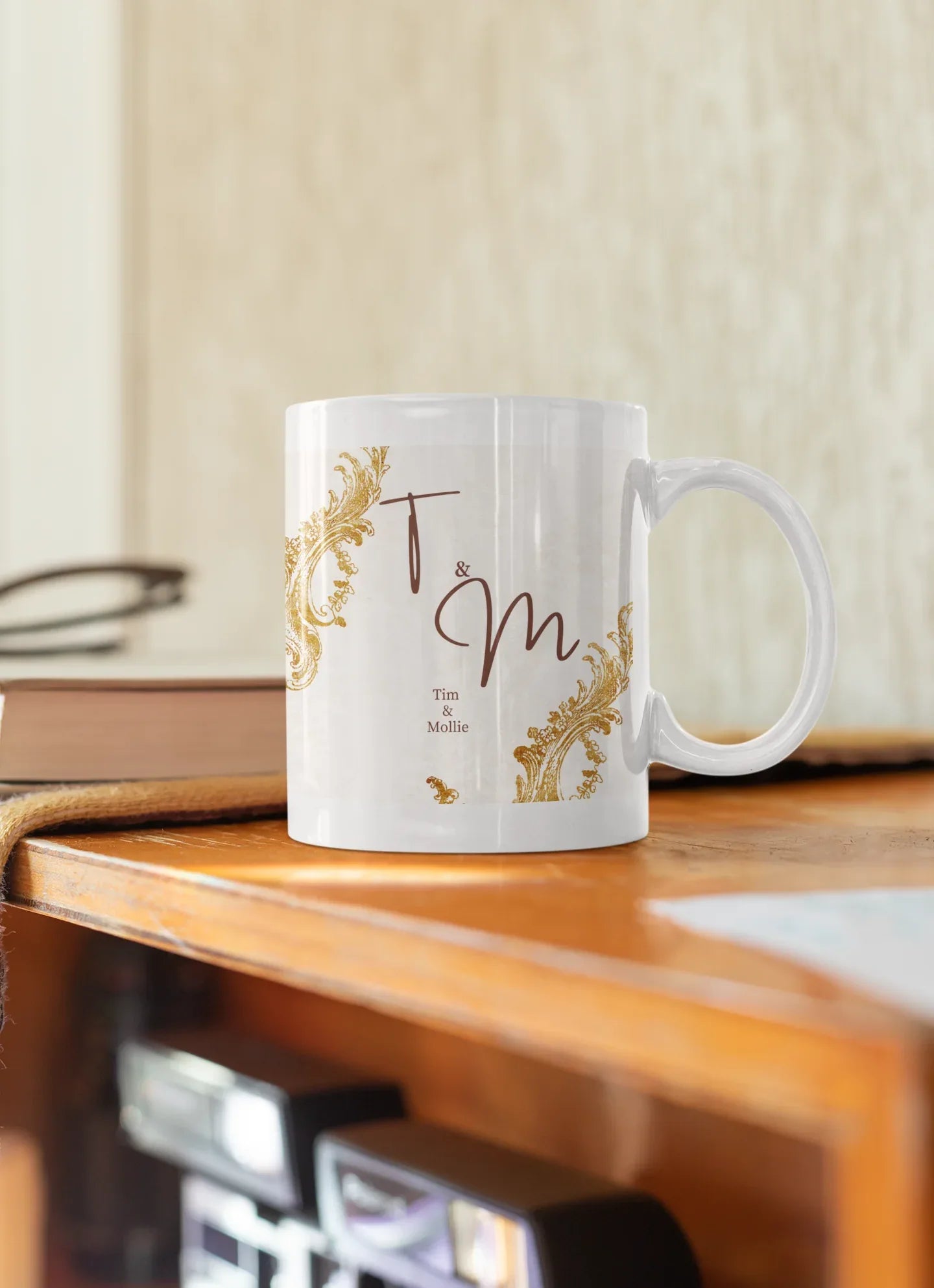 White mug with gold filigree corners and dark red 'T & M' design
