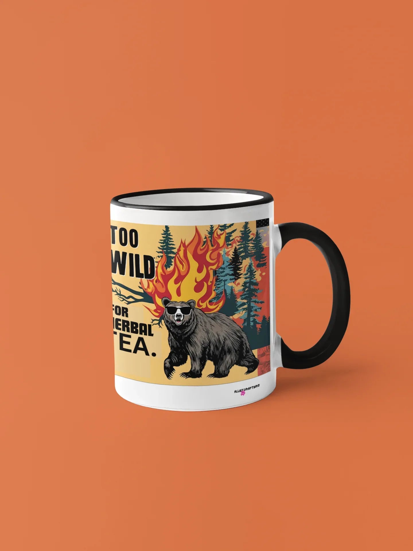Navy-handled ceramic mug with bear and flames artwork; text reads “TOO WILD FOR HERBAL TEA.”