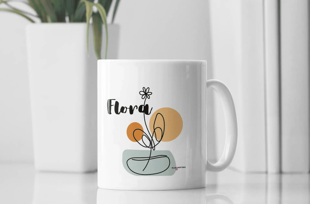 White ceramic mug with Flora name and floral pot graphic on the front