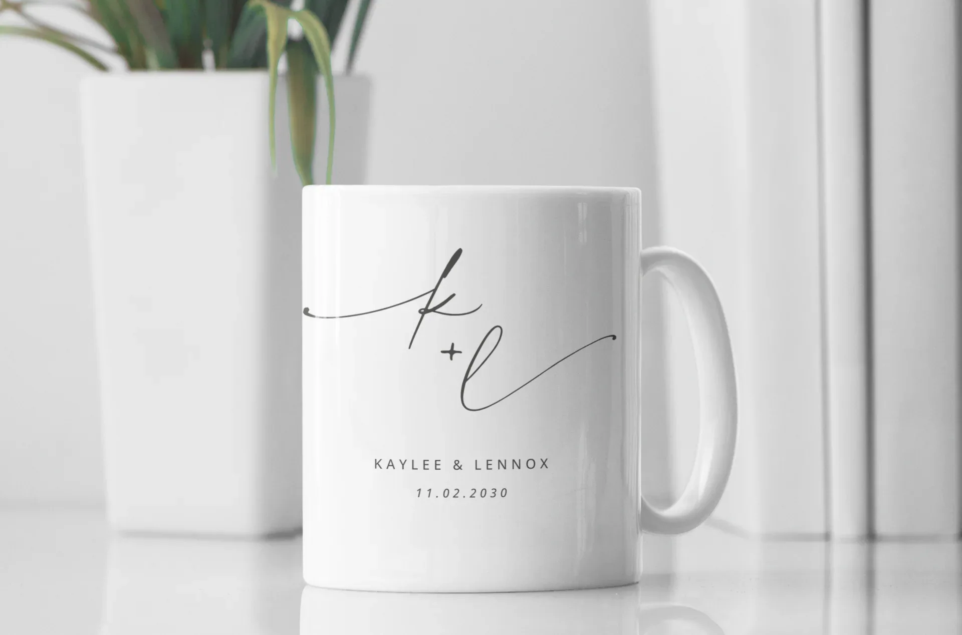 White ceramic mug with monogram k + l and date 11.02.2030, printed on front.