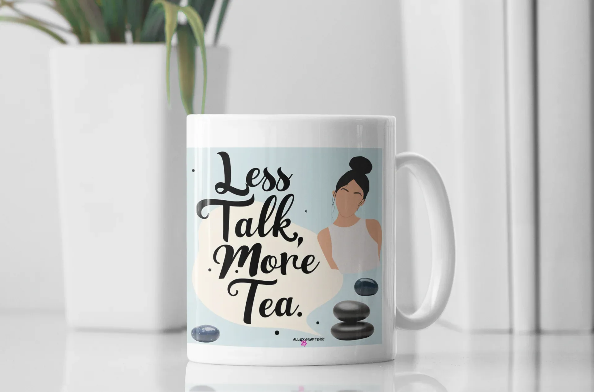 White tea mug with handle and 'Less Talk, More Tea' design with stones