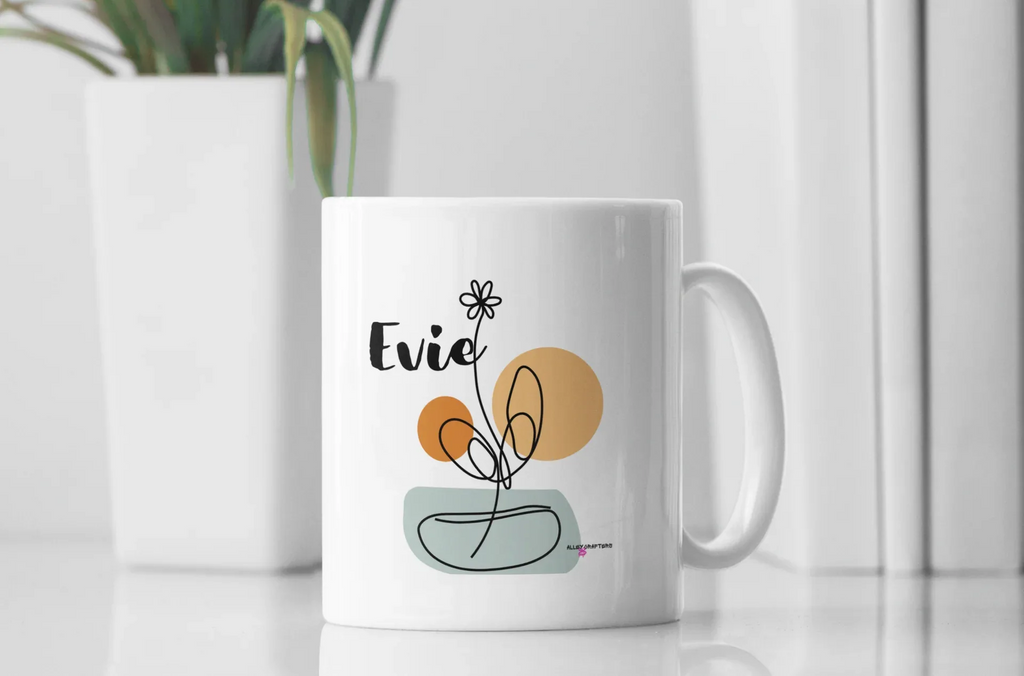 White ceramic mug with Evie name and floral swirl design on front, room setting.