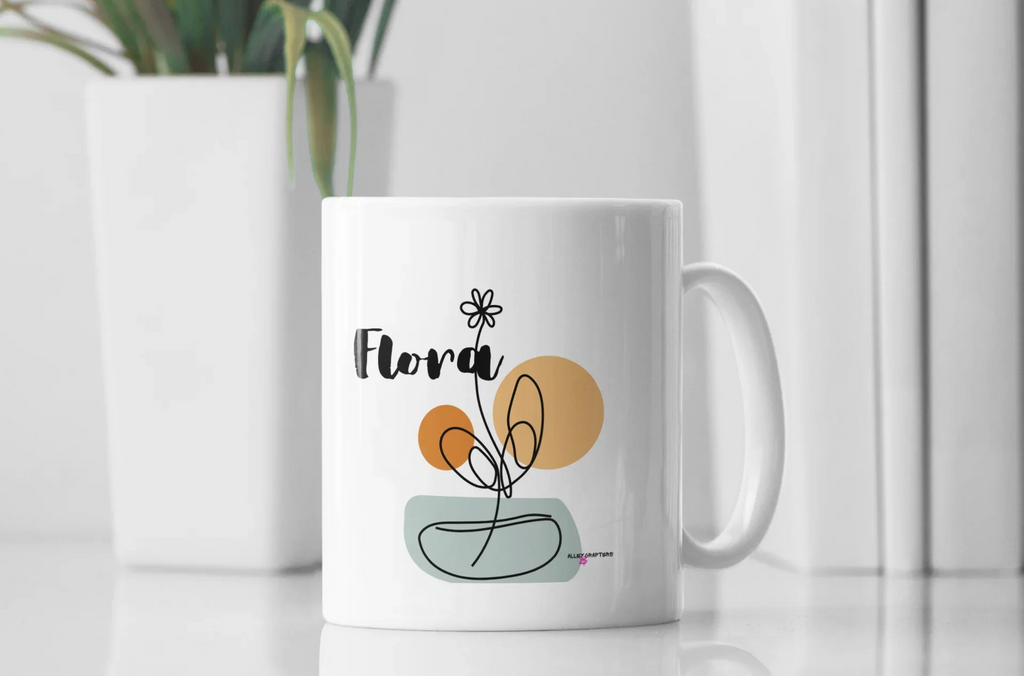 White ceramic mug with Flora name and floral pot graphic on the front