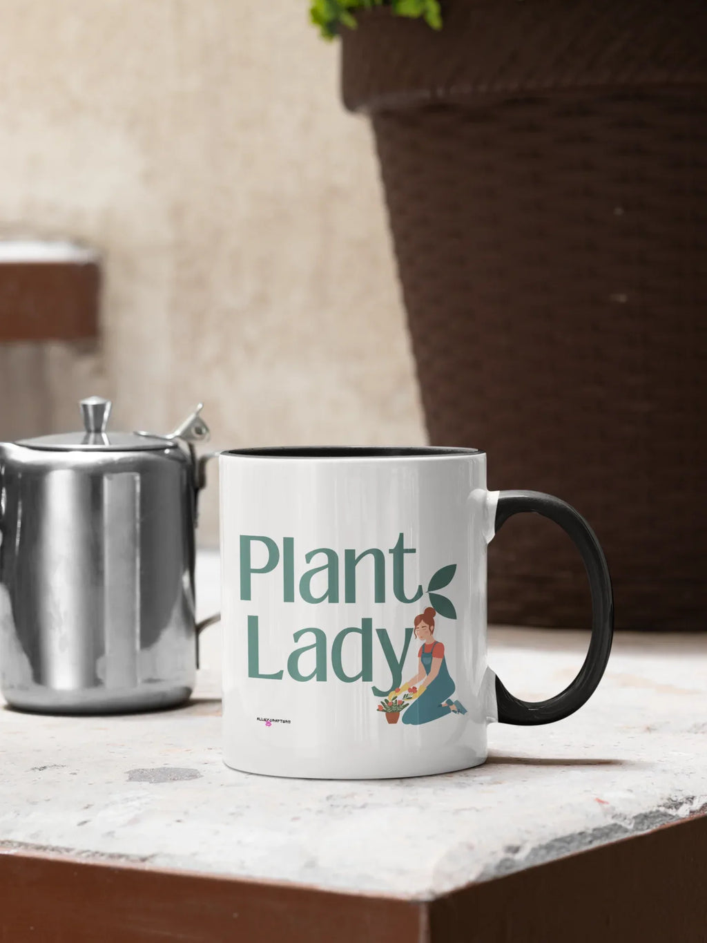 White coffee mug with black handle and “Plant Lady” botanical print, on counter