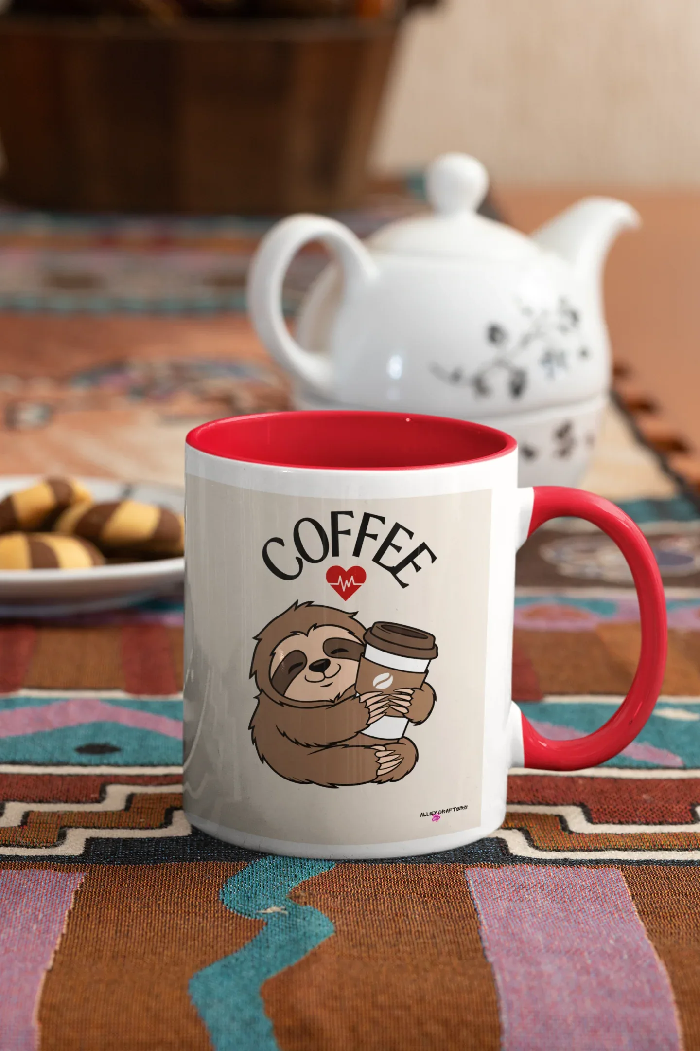 White coffee mug with red interior and handle, sloth graphic holding a coffee cup