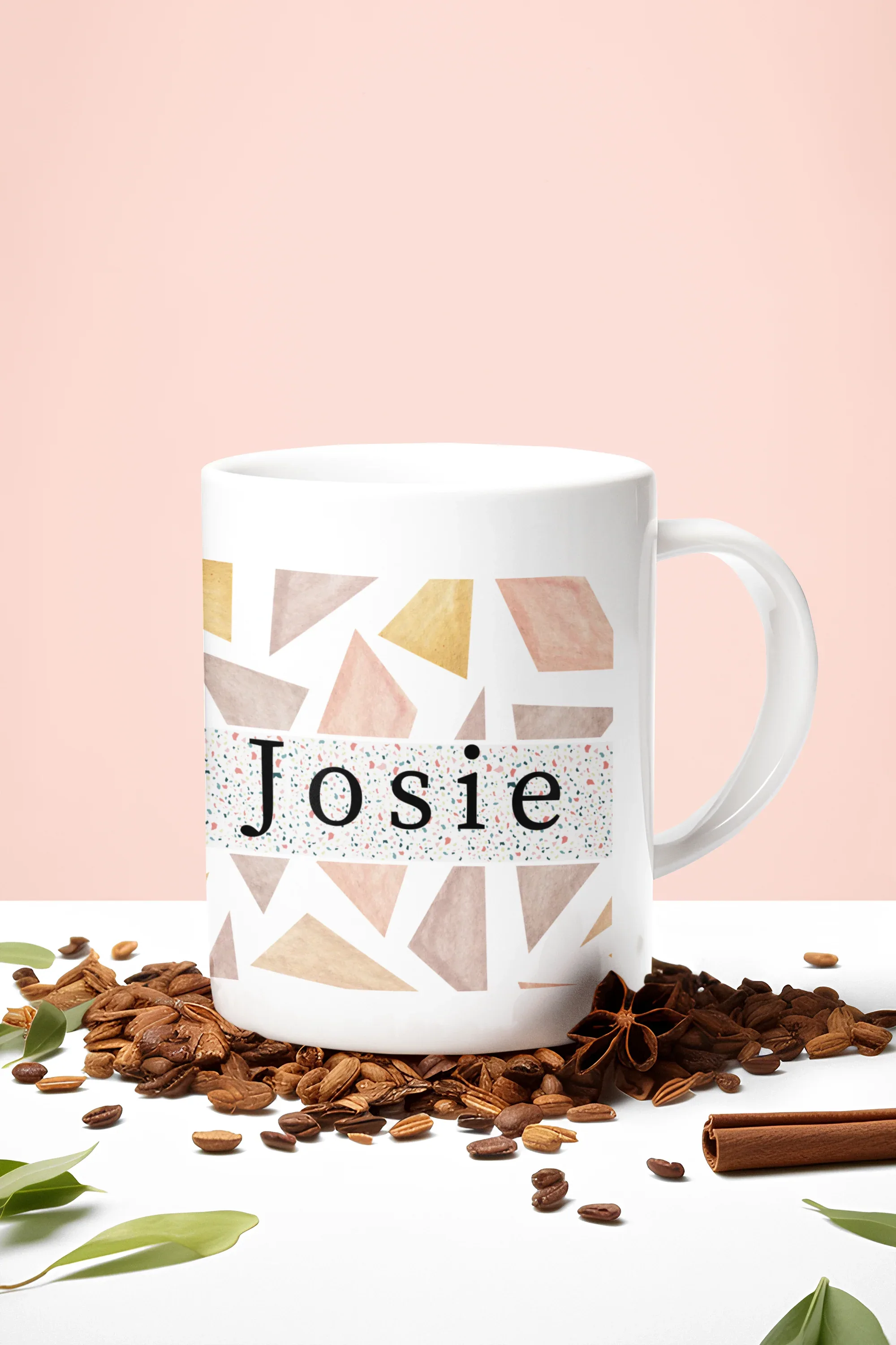 White mug with geometric triangles and name Josie, with coffee beans around it