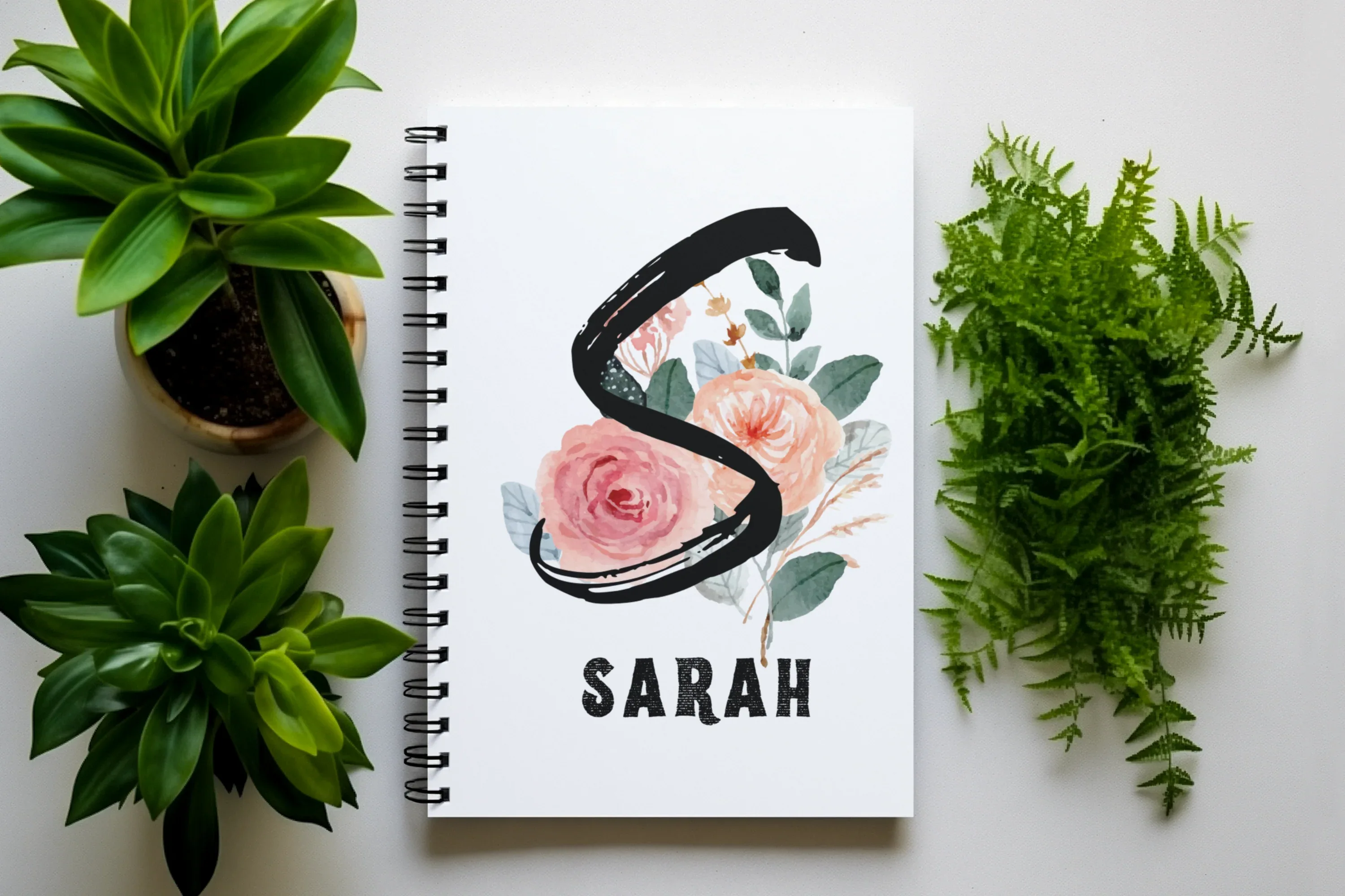 White A5 journal with spiral binding, floral initial and name SARAH on cover