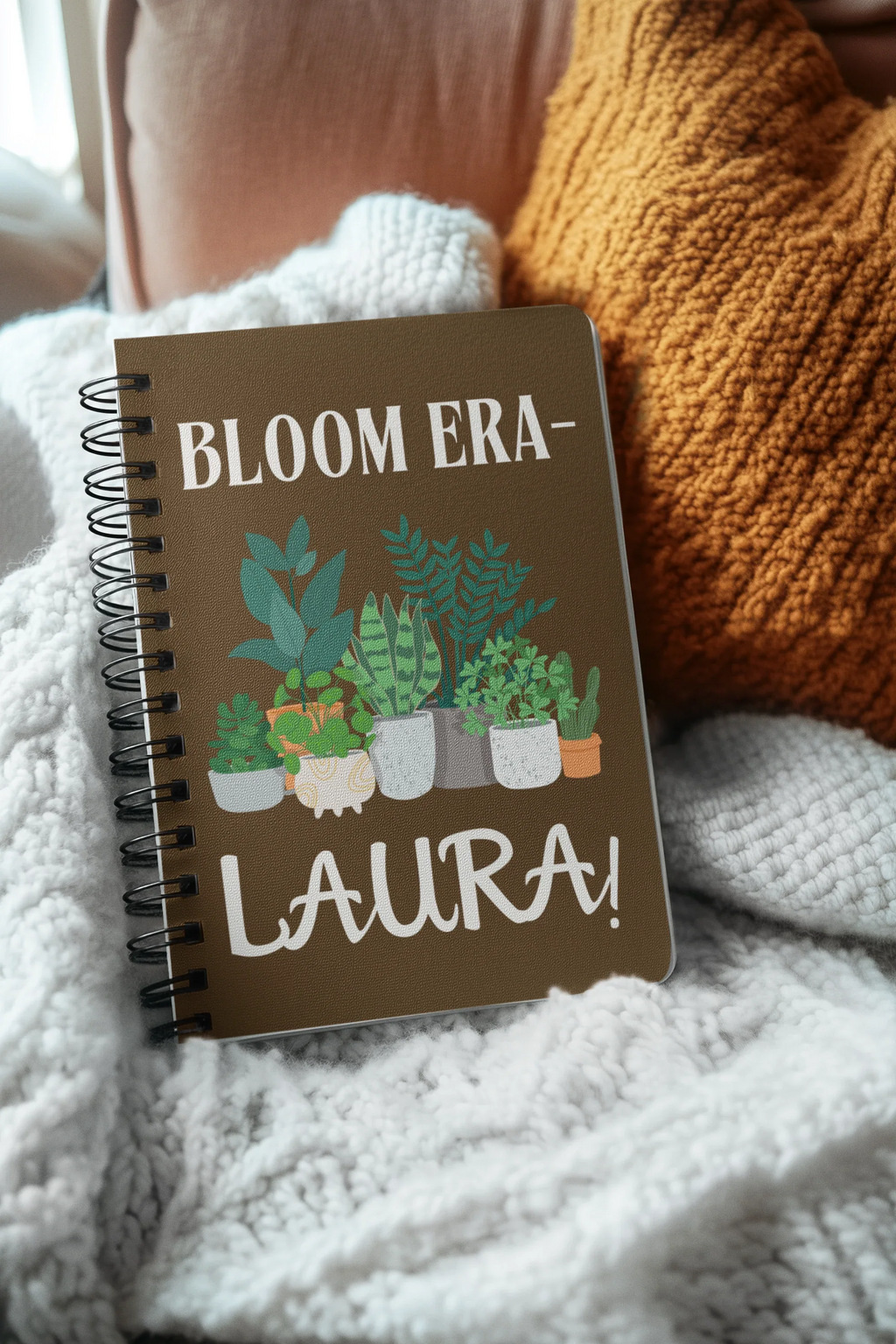 Personalised A5 lined notebook with dark brown cover, floral pots illustration and name LAURA.