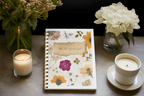 A5 wirebound floral softcover daily journal notebook with lined pages.
