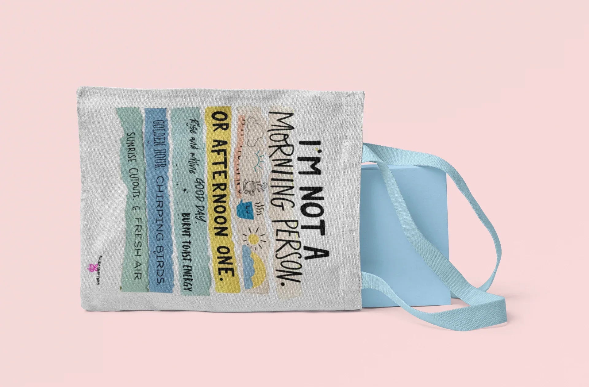 Light gray canvas tote bag with printed text and light blue ribbon straps