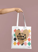 White heart-print tote bag with tan heart graphic and multicolor diamond pattern, short handles
