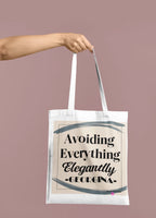 White canvas tote bag held by handle; “Avoiding Everything Elegantly” with blue graphic