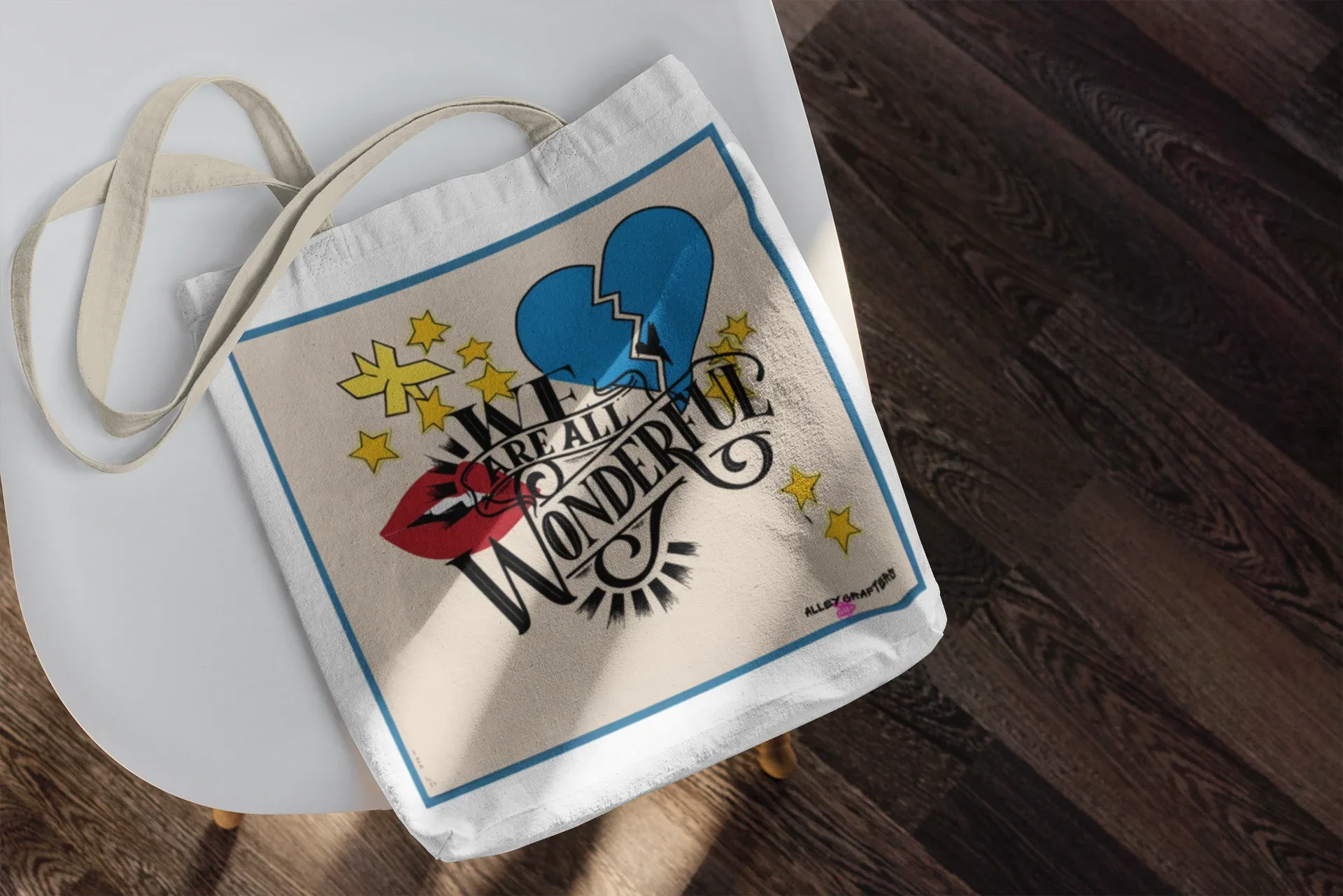 White tote bag with blue border and colorful heart graphic with text