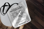 White tote bag with black graphic print of a sun and seated figure