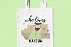 White tote bag with “who loves MATCHA” illustration on a flat front view.