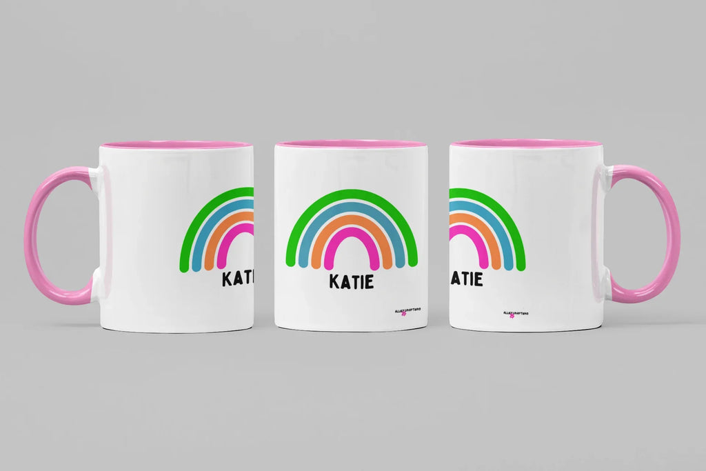 Set of three personalised rainbow mugs with name Katie, pink handles and rims.