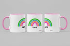Set of three personalised rainbow mugs with name Katie, pink handles and rims.