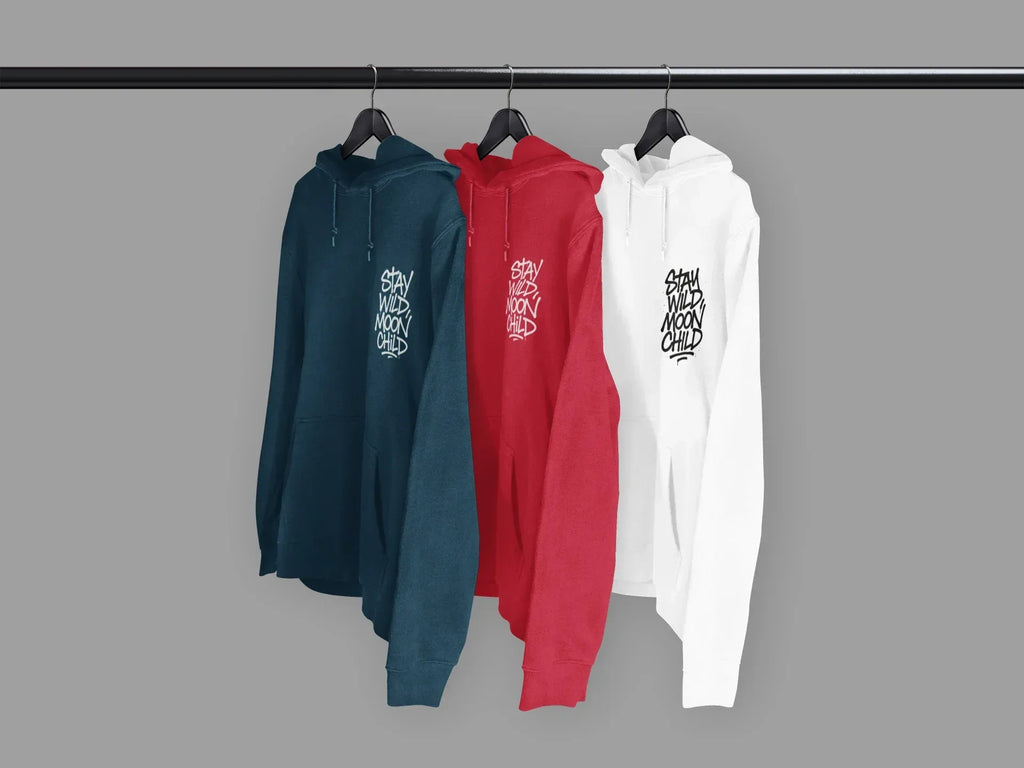 Hanging hoodies in teal, red, and white, each with “Stay Wild Moon Child” chest graphic