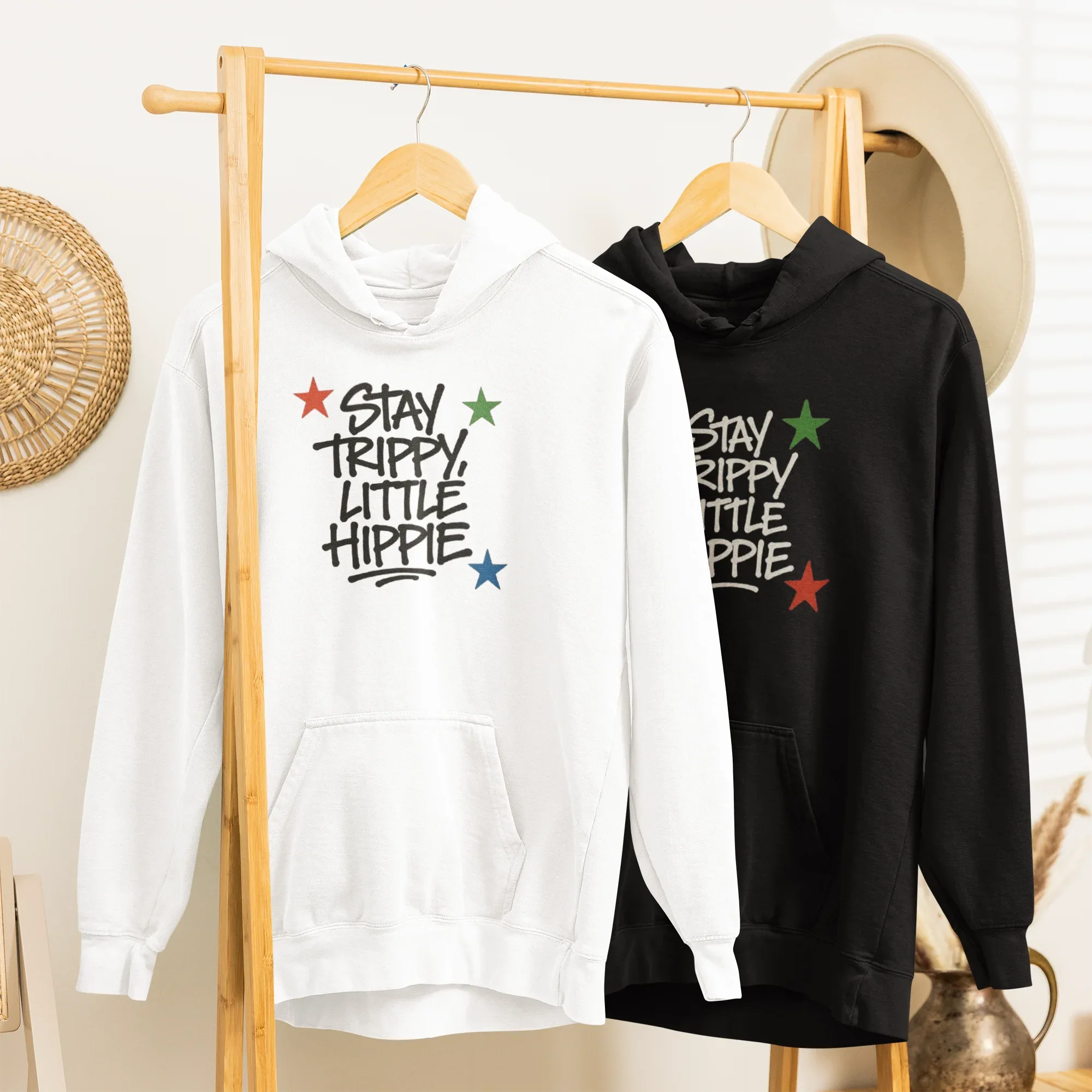 White and black hoodies with front "Stay Trippy Little Hippie" star text graphic