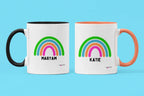 Personalised rainbow mugs set: MARYAM with black handle, KATIE with orange handle, rainbow names