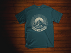 Teal short-sleeve T-shirt with mountain sunrise “RISE ABOVE” graphic