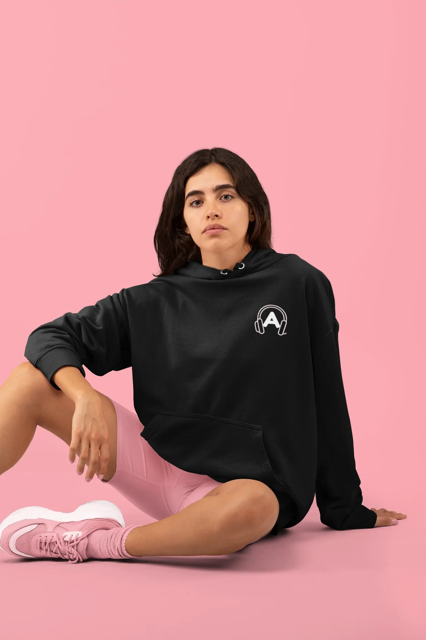 Black unisex sweatshirt with hood and embroidered headphone logo on chest