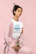 White unisex T-shirt on seated model, blue birds and floral name/year print.