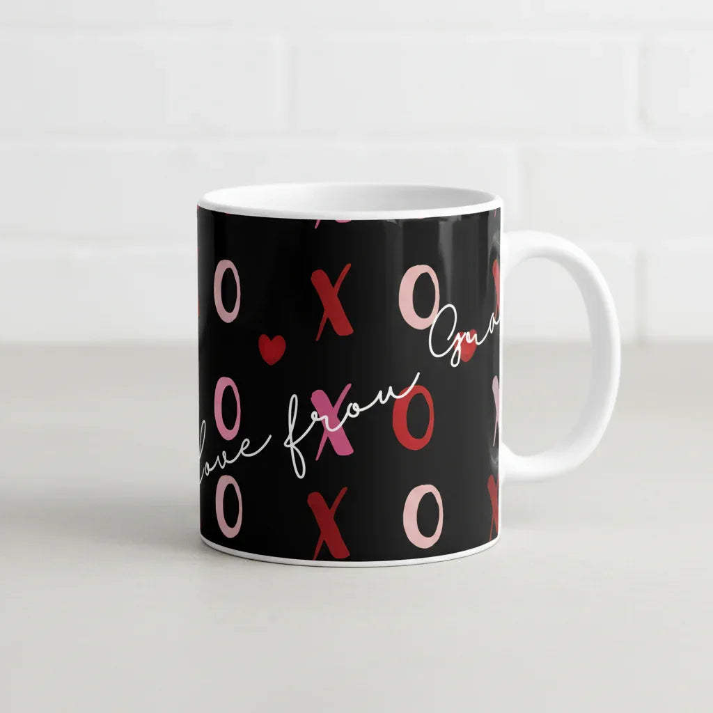 Black ceramic mug with pink/red XO hearts and “Love” script across the front