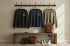Crewneck sweatshirts on wall rack in black, navy, and light tan