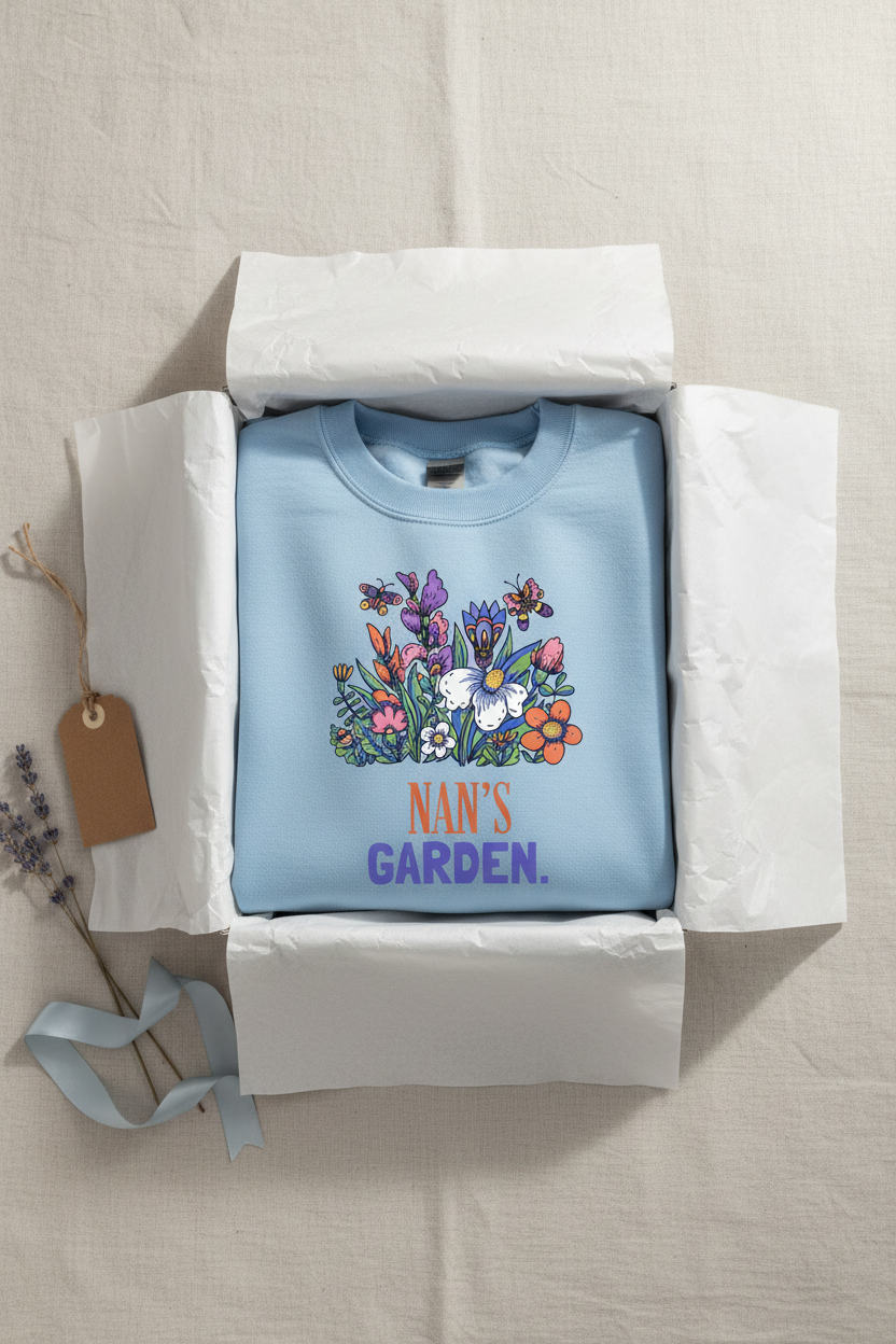 Sky blue crewneck sweatshirt in box with floral graphic and 'NAN'S GARDEN' print