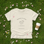 Natural cream tee flat lay on grass